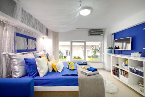 アテネにあるSantorini Style in Athens, Greeceの青と白のベッドルーム(ベッド1台、ソファ付)