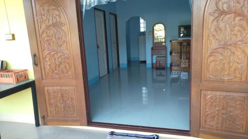 a large glass door in a room with blue walls at บ้านพักน้องจ็อบ in Baanphakrimlay 