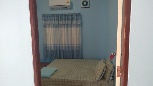 Cette petite chambre comprend un lit et une fenêtre. dans l'établissement บ้านพักน้องจ็อบ, à Baanphakrimlay 