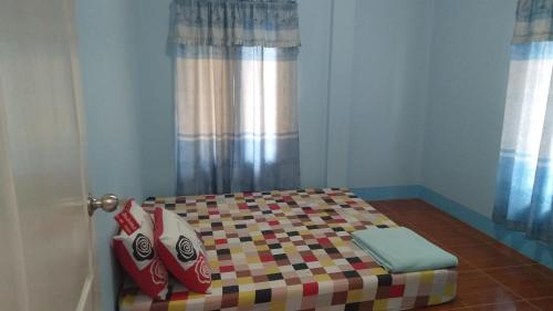 a small bed in a room with a door at บ้านพักน้องจ็อบ in Baanphakrimlay 