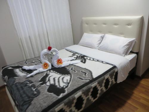 two swans made out of towels are sitting on a bed at La Casa De Yoni in Puno