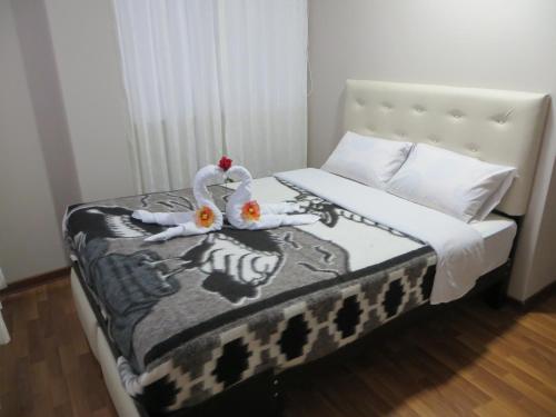 two swans sitting on a bed in a bedroom at La Casa De Yoni in Puno