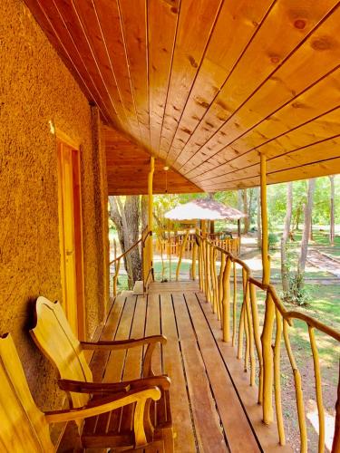 a porch with chairs and umbrellas on a house at La Pentera in Hambegamuwa