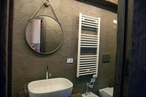 a bathroom with a sink and a mirror on the wall at La Canonica - charming self-catering apartments in Nizza Monferrato in Nizza Monferrato
