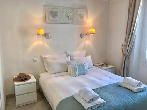 a bedroom with a large white bed with towels on it at Pimms Apartment in Antibes