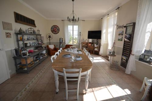 Longeves的住宿－Aux 4 Cornes - Chambre d'hôtes，一间带木桌和椅子的用餐室