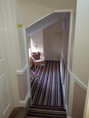 a hallway with a chair and a couch in a room at Riverside Guest House in Sleaford