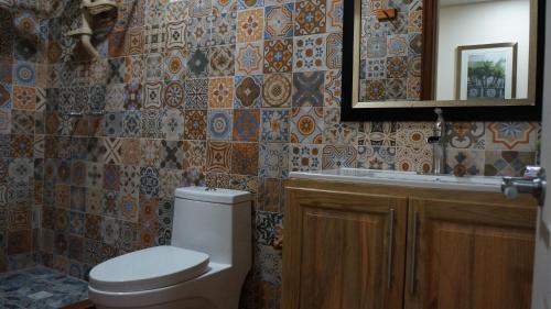 La salle de bains est pourvue de toilettes, d'un lavabo et d'un miroir. dans l'établissement Pirates Rock 101, à Utila