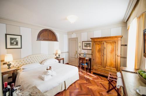 a bedroom with a bed with a teddy bear on it at Hotel Villa Beccaris in Monforte dʼAlba