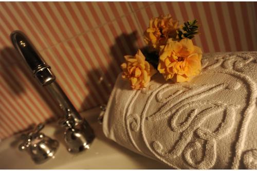 a white towel with flowers on top of a table at Hotel Villa Beccaris in Monforte dʼAlba