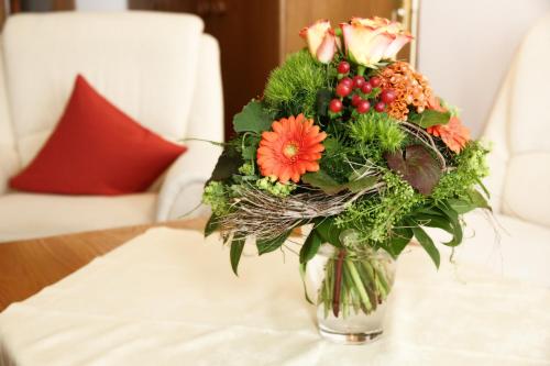 a vase filled with flowers on a table at Appartementhaus Albrecht in Bad Füssing