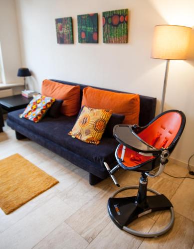 a living room with a blue couch and a chair at Suite 30 - OvernachteninStijl in Groningen