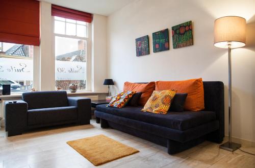a living room with a blue couch and a chair at Suite 30 - OvernachteninStijl in Groningen