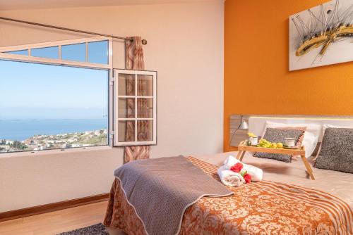 ポンタ・ド・ソルにあるCasa Por Do Solのベッドルーム1室(ベッド1台、大きな窓付)
