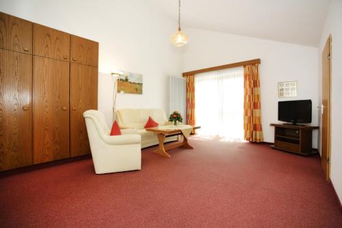 a living room with a couch and a tv at Appartementhaus Albrecht in Bad Füssing