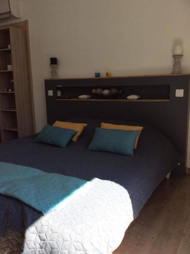 a bedroom with a large bed with blue pillows at Au bien être in Bastia
