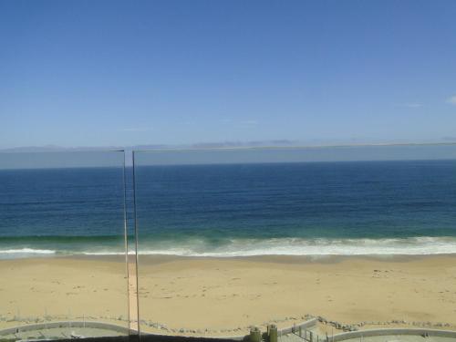 a view of the beach and ocean from a building at Condominio Arena Maris in Algarrobo
