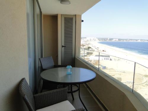 a room with a table and a view of the beach at Condominio Arena Maris in Algarrobo