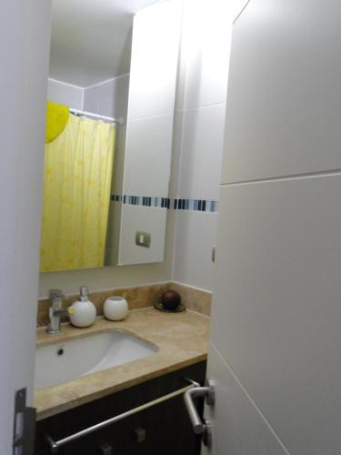 a bathroom with a sink and a mirror at Condominio Arena Maris in Algarrobo