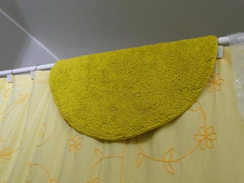 a yellow towel is hanging on a curtain at Condominio Arena Maris in Algarrobo
