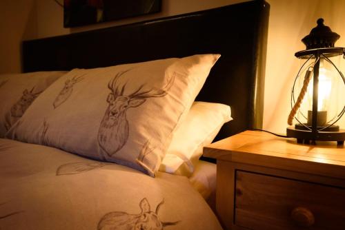 a bed with a pillow with drawings of deer on it at The Old Chemist in Cullen