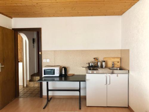 a small kitchen with a table and a microwave at Linda Apartment 33 in Interlaken