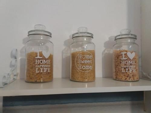 four glass jars filled with food sitting on a shelf at Studio Rafaela in Matala