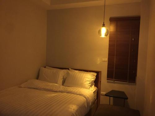 a bedroom with a bed with white sheets and a lamp at U Chiangkhan in Chiang Khan