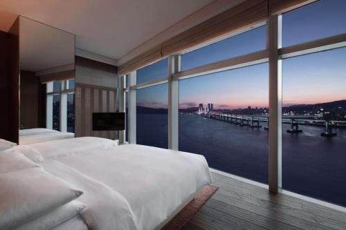a hotel room with two beds and a large window at Park Hyatt Busan in Busan