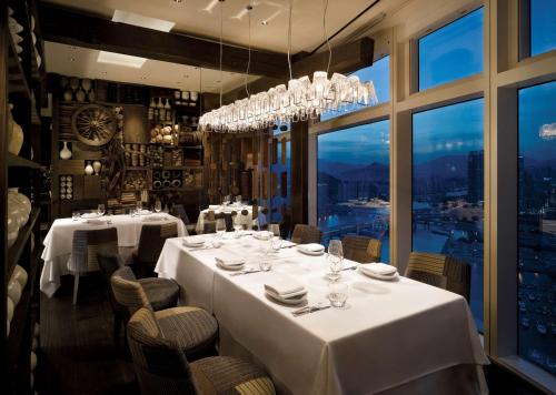 a restaurant with white tables and chairs and a large window at Park Hyatt Busan in Busan
