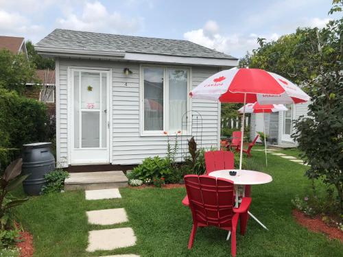a table and chairs and an umbrella in a yard at Oakwood Motel in Gravenhurst