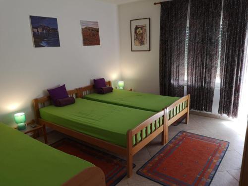 two beds in a room with green sheets at David in 4 in Primošten
