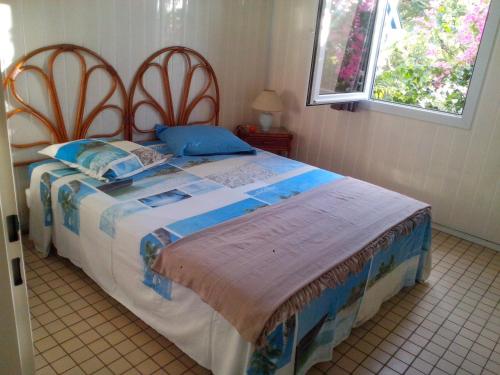 een slaapkamer met een groot bed met twee houten hoofdeinden bij Gite Palmier in Bouillante