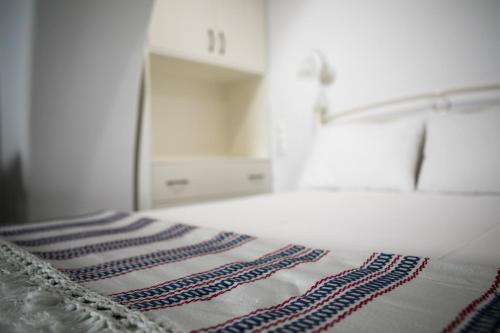 een bed met een gestreepte deken erop bij CASA NEL BORGO in Naxos Chora