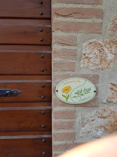 a sign on the side of a brick wall at Agriturismo Bio Tra Cielo e Terra in Grutti