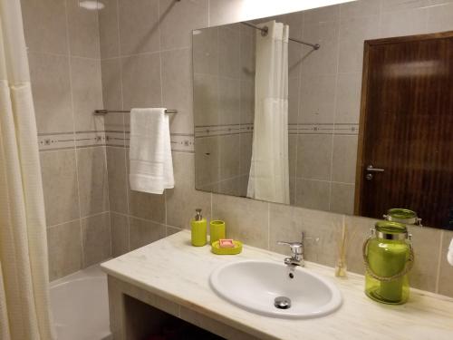 een badkamer met een wastafel, een spiegel en een bad bij CASA SIMBA , where the fun begins in Ponta Delgada
