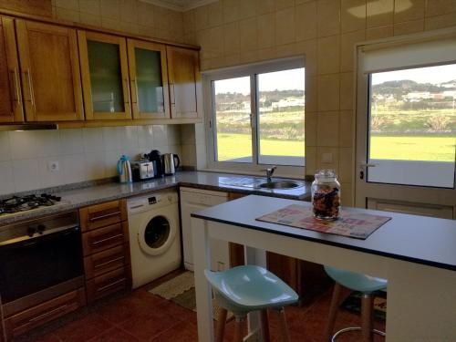 a kitchen with a counter and a sink and two windows at CASA SIMBA , where the fun begins in Ponta Delgada