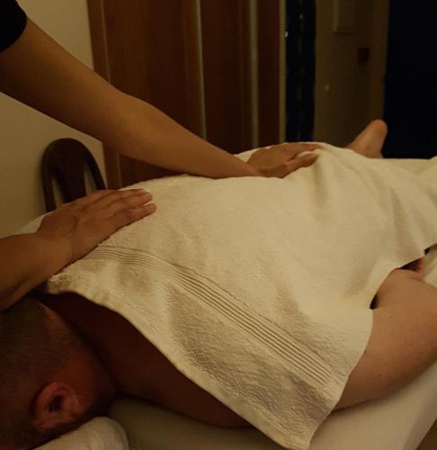 a man laying in a bed with a blanket at zimmer cigale in Odem