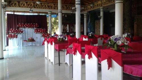 a banquet hall with red tables and chairs and flowers at Green Valley Holiday Resort in Haputale