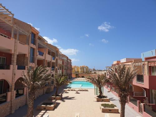 a view of a courtyard with palm trees and a swimming pool at Aparthotel Por do Sol in Sal Rei