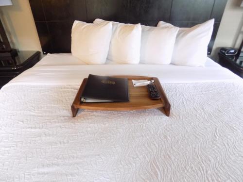 a bed with a tray with a laptop on it at Breck Inn in Breckenridge