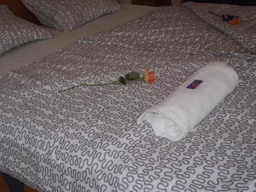 a rolled up towel on top of a bed at Mediterrán Vendégház in Kecskemét