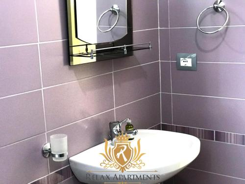 La salle de bains est pourvue d'un lavabo blanc et d'un miroir. dans l'établissement Durmishi Rooms & Apartments & Beach, à Saranda