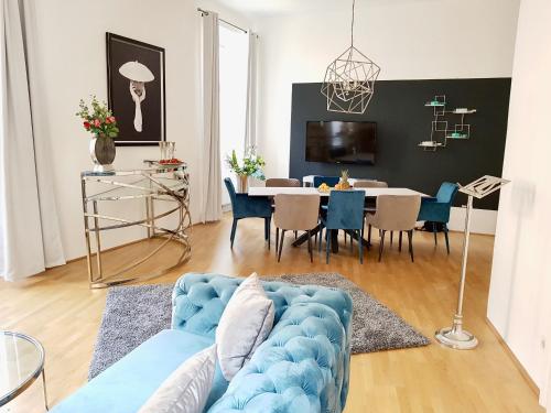 ein Wohnzimmer mit einem blauen Sofa und einem Tisch in der Unterkunft Belle Epoque in Wien