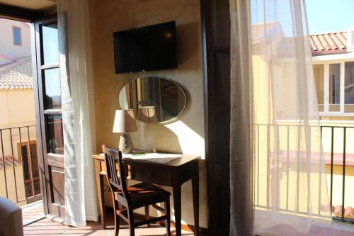 a room with a desk with a mirror and a window at B&B Rivellini in Tropea