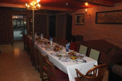a long table in a dining room with a white table cloth at Chateau Chikovani in Gordi
