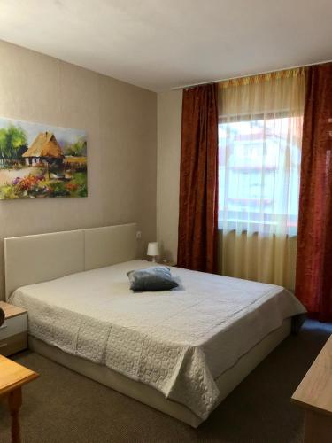 a bedroom with a large bed and a window at Guest House Urdoviza in Kiten