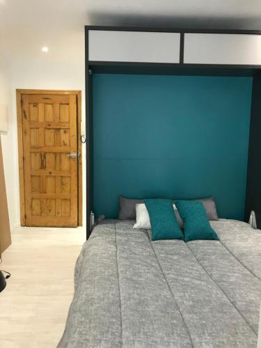 um quarto com uma cama grande e uma parede azul em A Casiña do Leo em Ourense