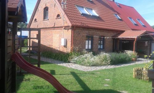 a house with a slide in front of it at Białka B in Białogóra