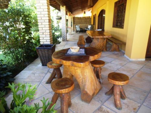 a patio with wooden tables and stools on a patio at Pousada Iguana in Canoa Quebrada
